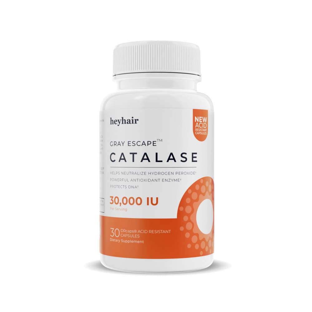 Man smiling and holding a supplement bottle while taking a pill.